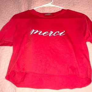 Red crop top says “merci”